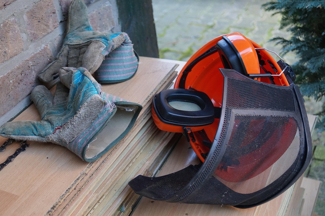 Work gloves and a hand saw resting on a cut log